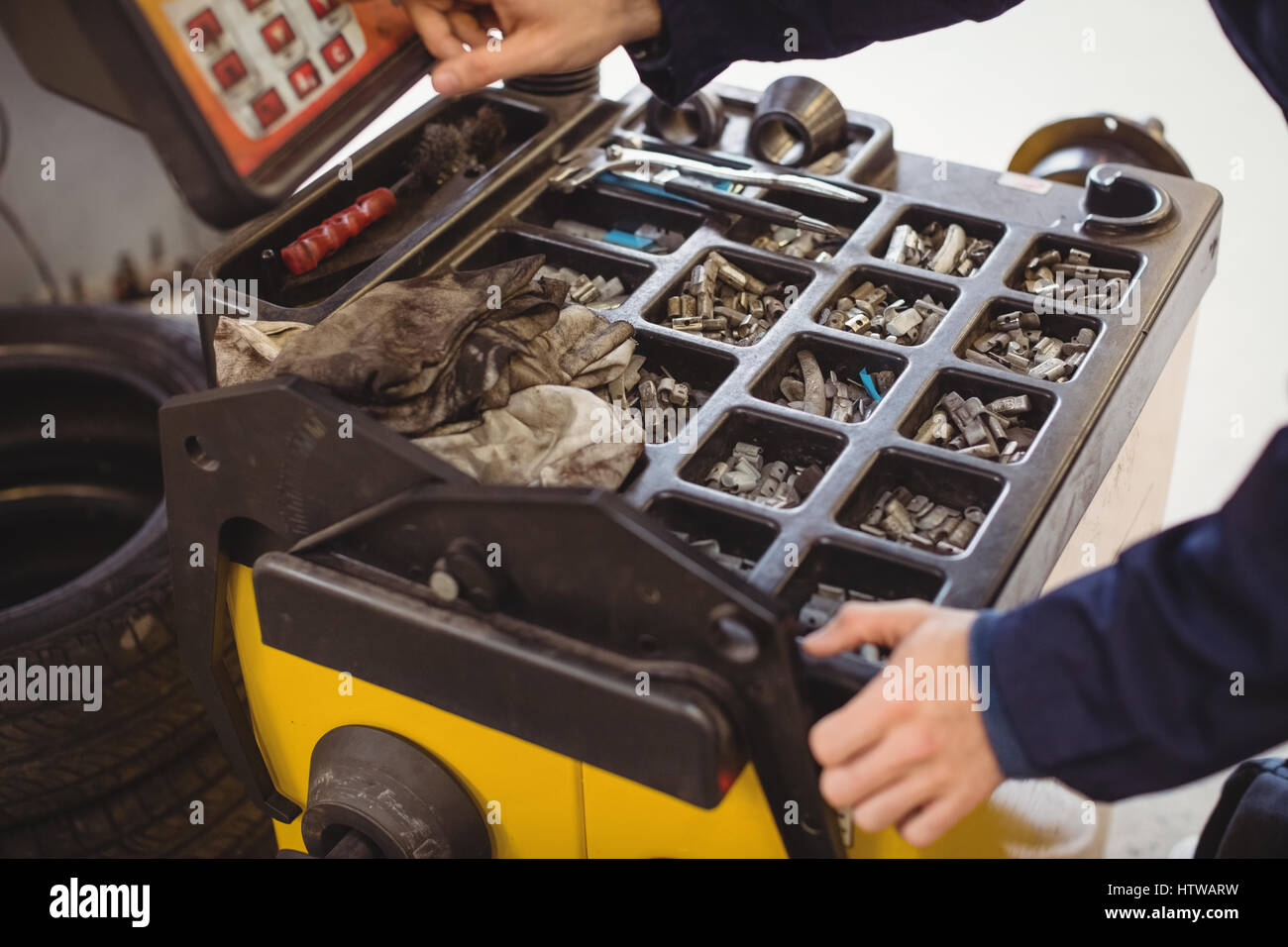 Le mani del meccanico utilizzando electronic dispositivo diagnostico e strumenti vari Foto Stock