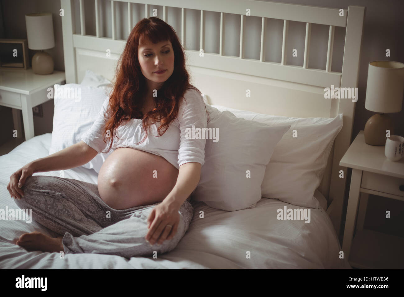Premurosa donna incinta rilassante sul letto Foto Stock