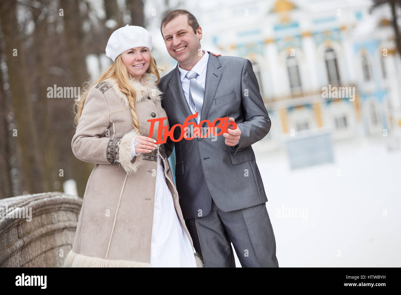 Felice giovani sposi tenendo in mano la parola russa di amore. Stagione invernale Foto Stock