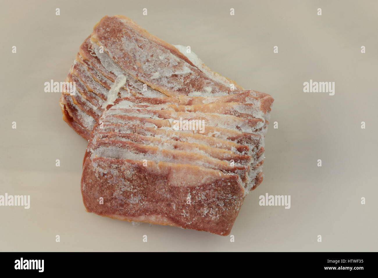 Tacchino congelati strisce di bacon lo scongelamento sulla piastra bianca Foto Stock
