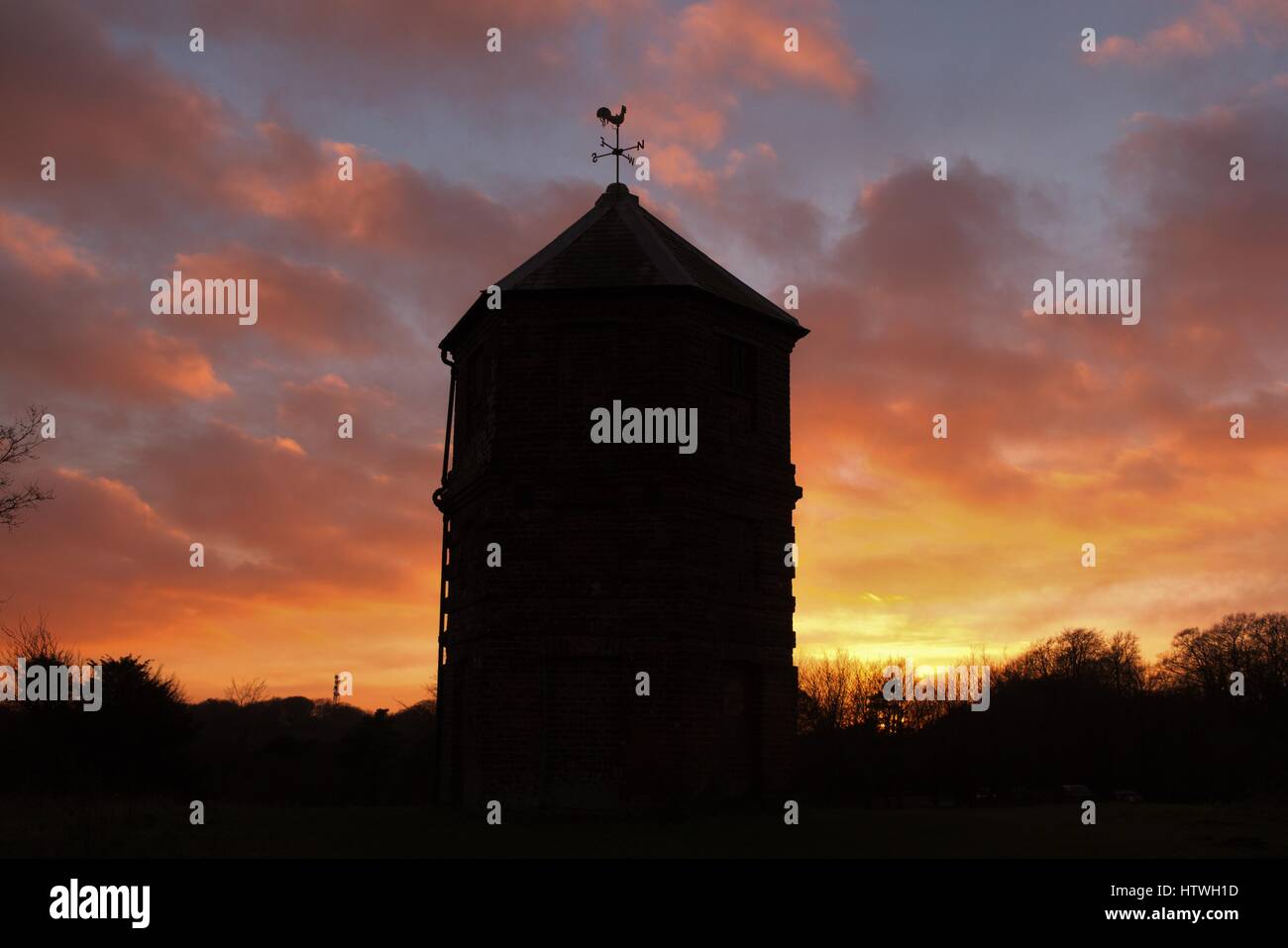 Il pepe-box follia al tramonto. Di forma insolita della torre di vedetta sul sud-downs campagna. Foto Stock