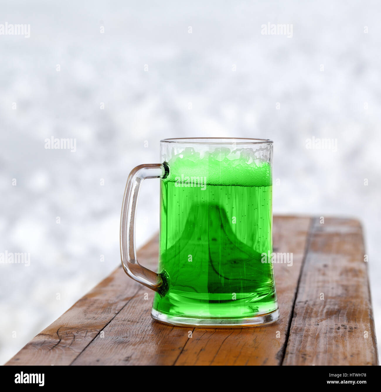 San Patrizio giorno. Pieno di freddo fresco bicchiere di birra verde sulla panca di legno. Foto Stock