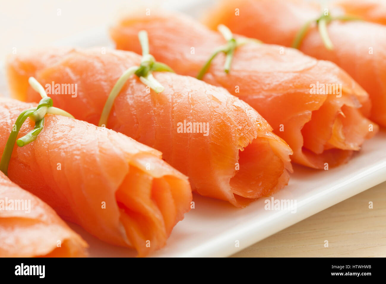 Involtini di salmone affumicato con erba cipollina come uno snack Foto Stock