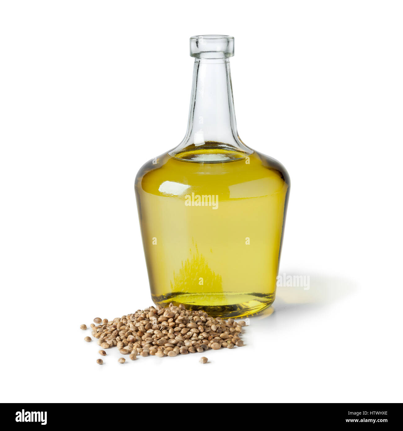 Bottiglia con olio di canapa e senza guscio di canapa su sfondo bianco Foto Stock