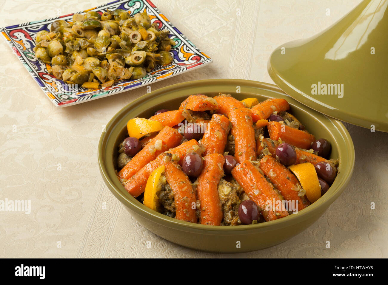 Marocchina tajine alla moda con pollo, carote, olive e conserve di limone con un lato piatto di cavoli di Bruxelles Foto Stock