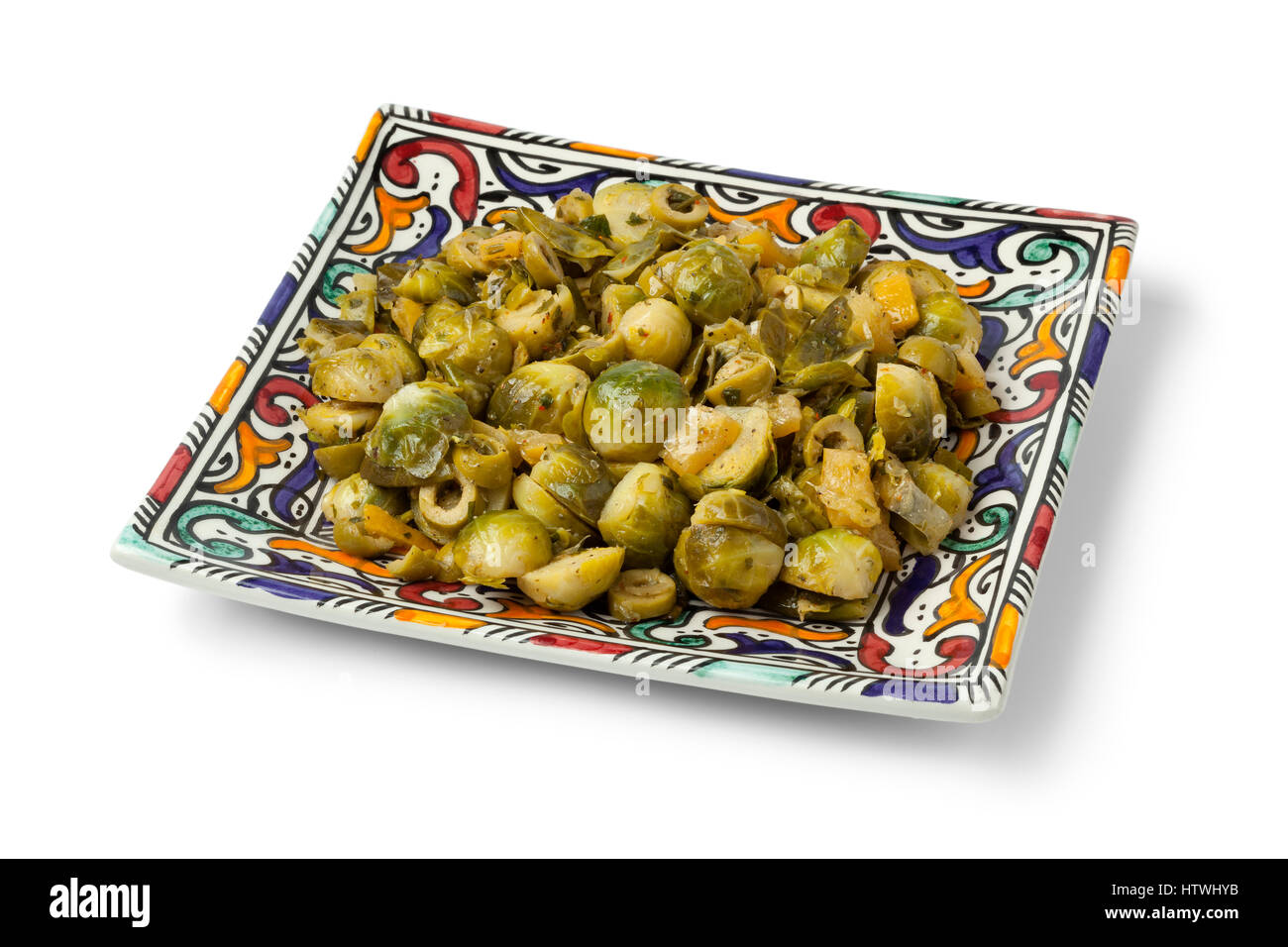Piatto marocchino con cavolini di Bruxelles e conserve di limone su un piatto moderno su sfondo bianco Foto Stock