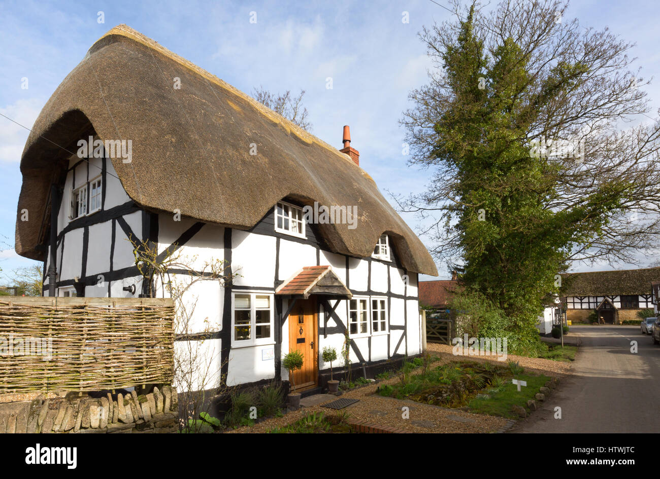 Inglese tradizionale cottage con il tetto di paglia nel villaggio di Elmley Castello, Worcestershire Inghilterra REGNO UNITO Foto Stock