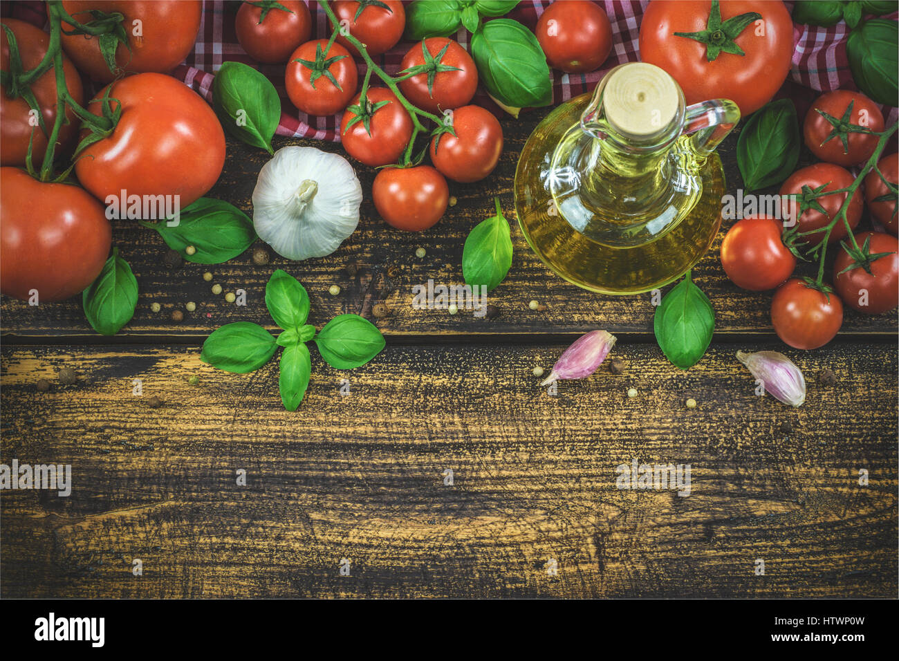 Tettuccio di colpo di ingredienti classici della cucina italiana: basilico, aglio, olio d'oliva, pepe su una tavola di legno tabella vintage (reducet tono) Foto Stock