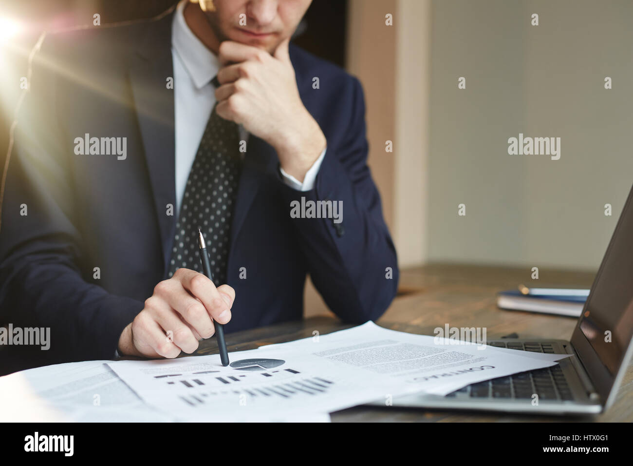 Closeup ritratto di un irriconoscibile imprenditore di successo vestita di nero abito formale analisi statistiche di finanza e documenti del contratto alla scrivania, sottile Foto Stock