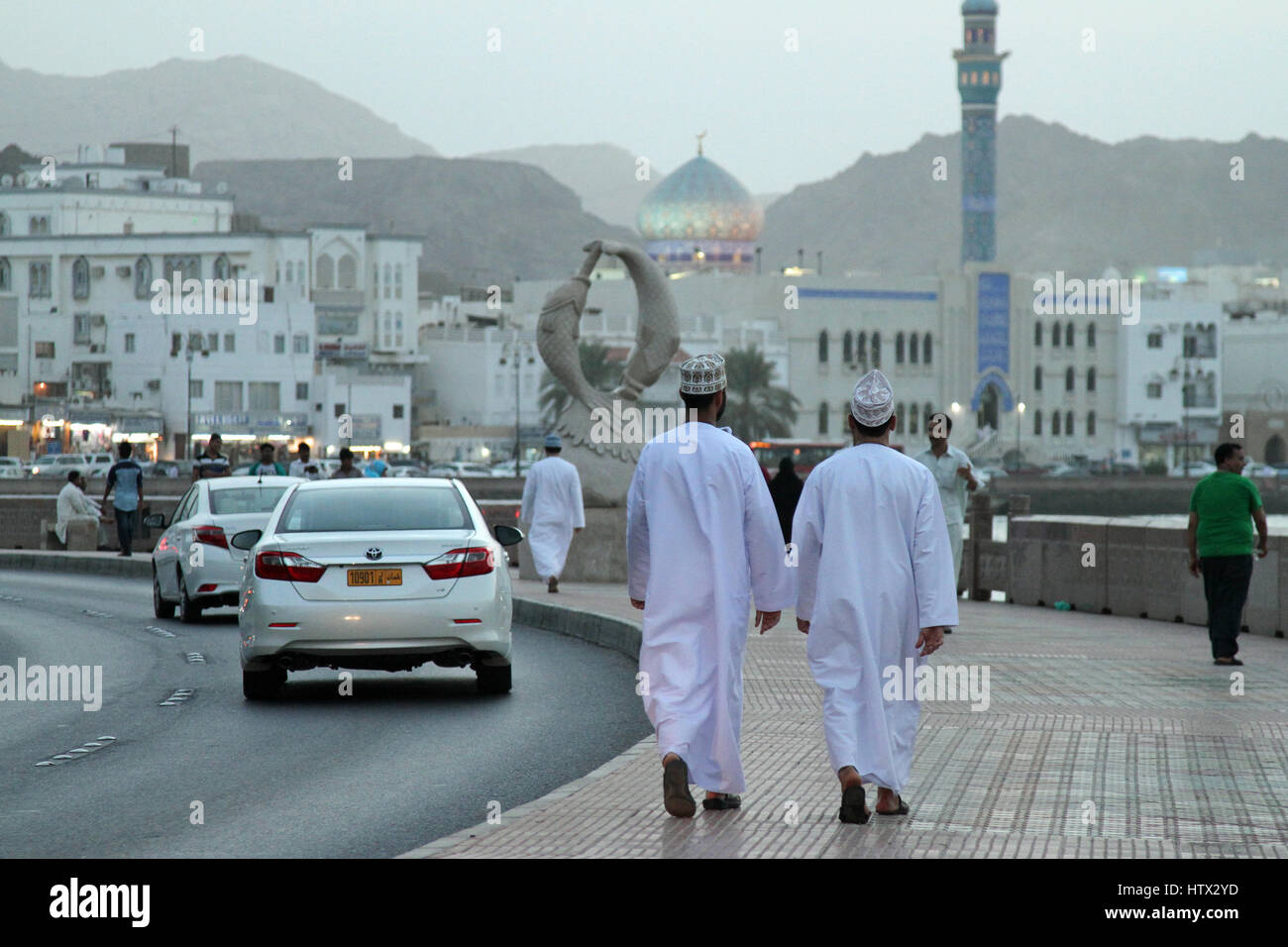 Una coppia di Omani locale gli uomini a piedi lungo Muttrah corniche di sera, in Muscat Oman Foto Stock