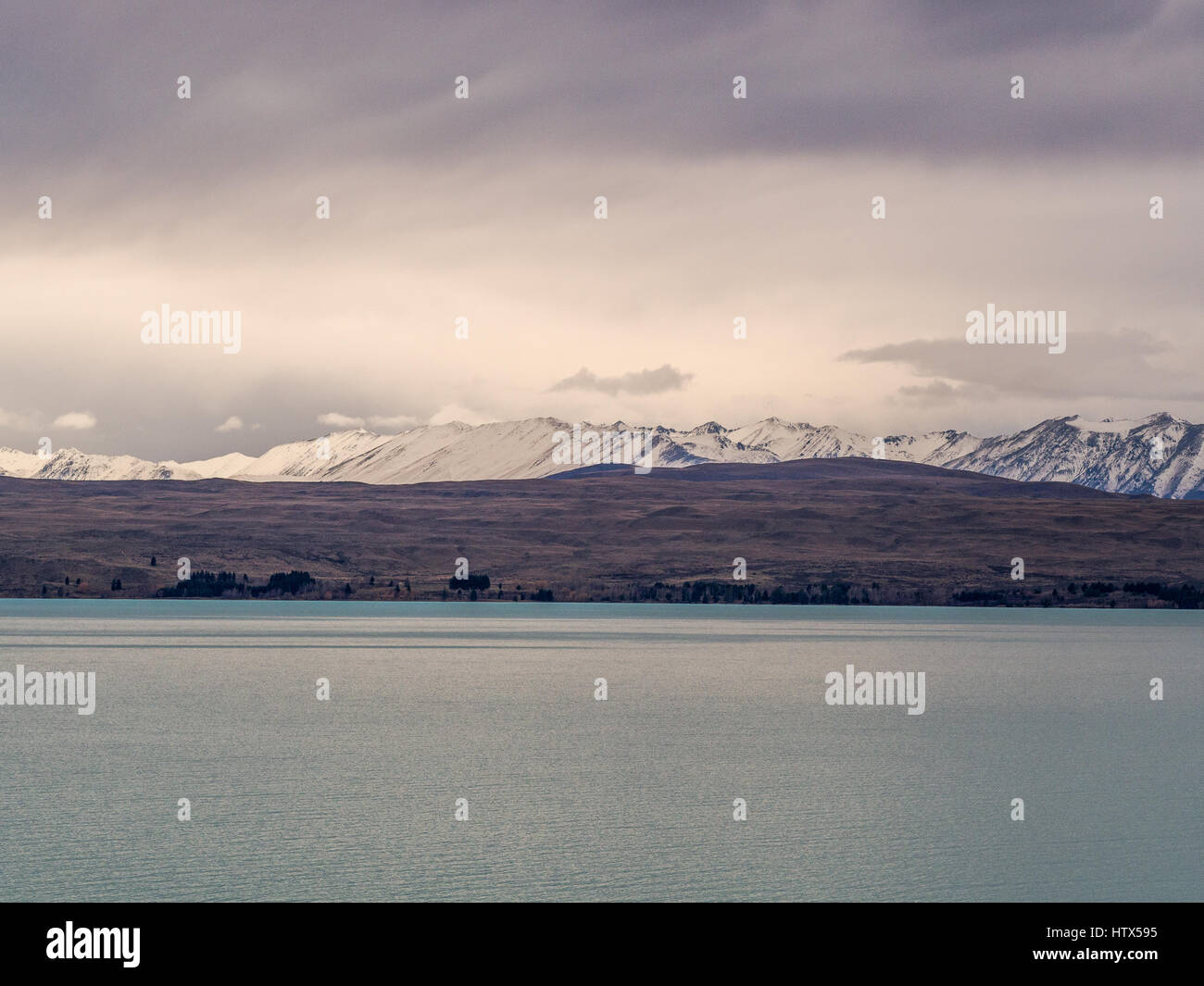 Lago alpino con vista delle montagne visto sopra l'acqua. Lago Pukaki, Mackenzie paese, South Island, in Nuova Zelanda. Foto Stock