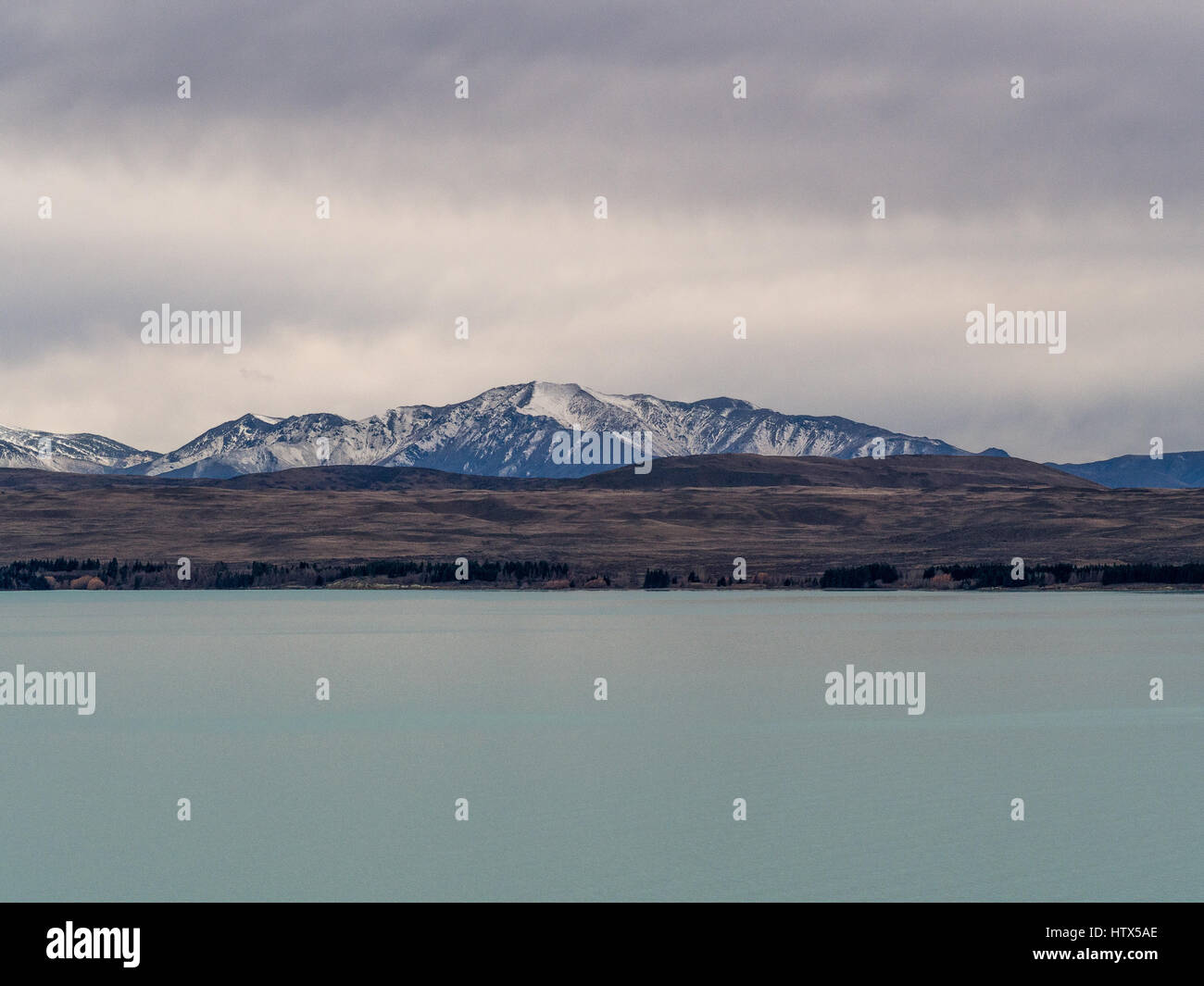 Lago alpino con vista delle montagne visto sopra l'acqua. Lago Pukaki, Mackenzie paese, South Island, in Nuova Zelanda. Foto Stock