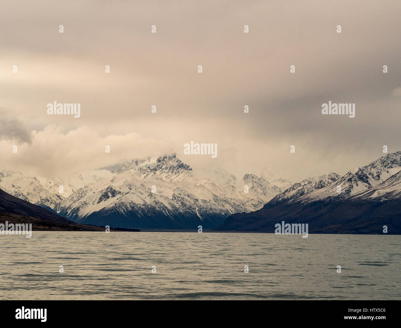 Lago alpino con vista delle montagne visto sopra l'acqua. Lago Pukaki, Mackenzie paese, South Island, in Nuova Zelanda. Foto Stock
