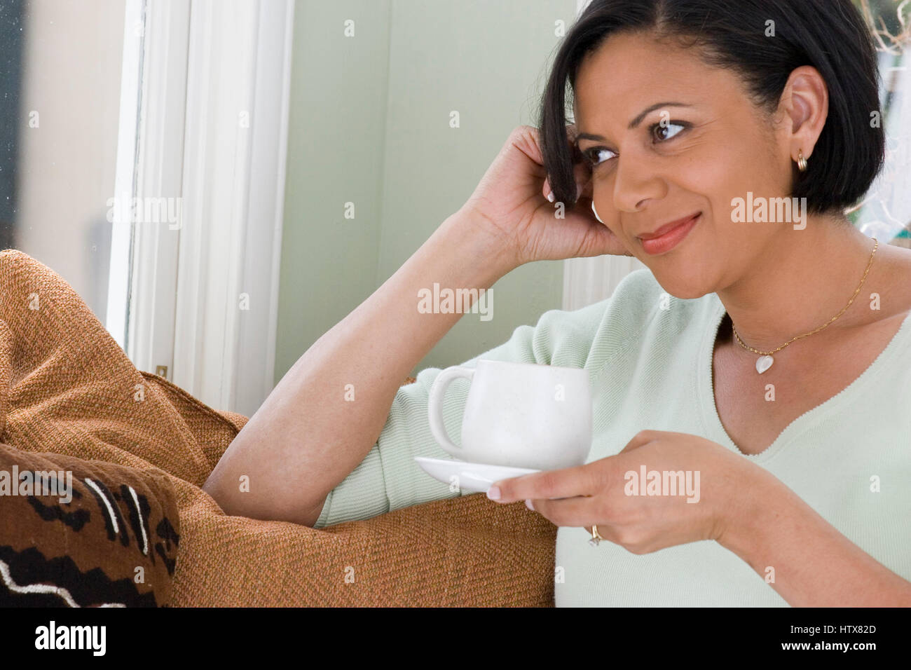 Coppia americano africano donna lettura sul divano. Foto Stock