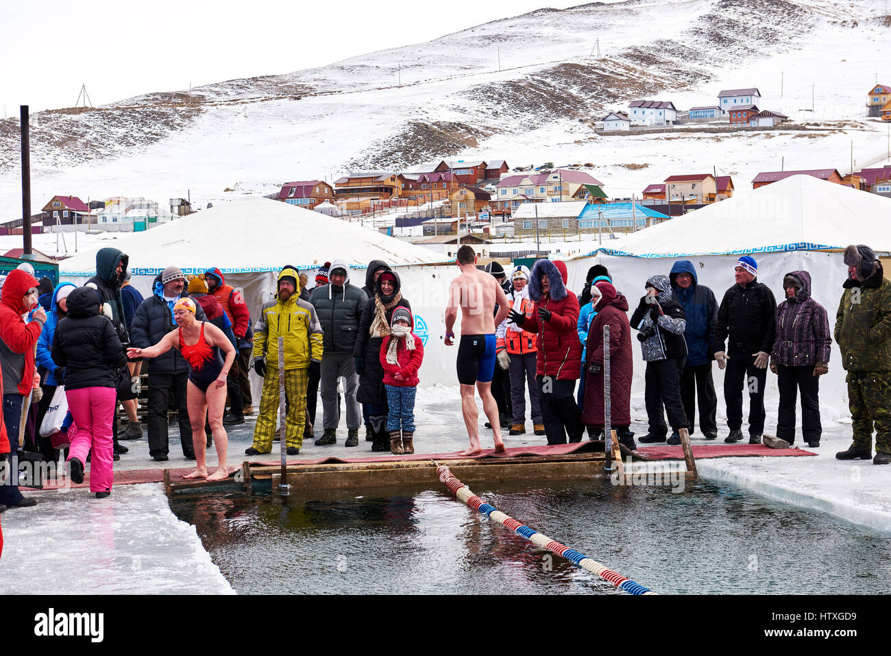 SAHYURTA ,Regione di Irkutsk, Russia - marzo 11.2017: Coppa di Baikal. Piscina invernale. Nuotatori è venuto fuori di acqua dopo la finitura e gruppo di tifosi a bordo della Foto Stock