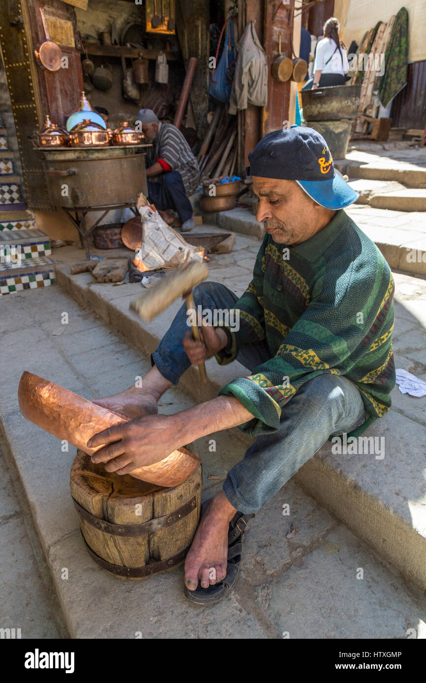 Fes, Marocco. Posizionare Seffarine. Martellatura artigiano un recipiente di rame in forma. Foto Stock