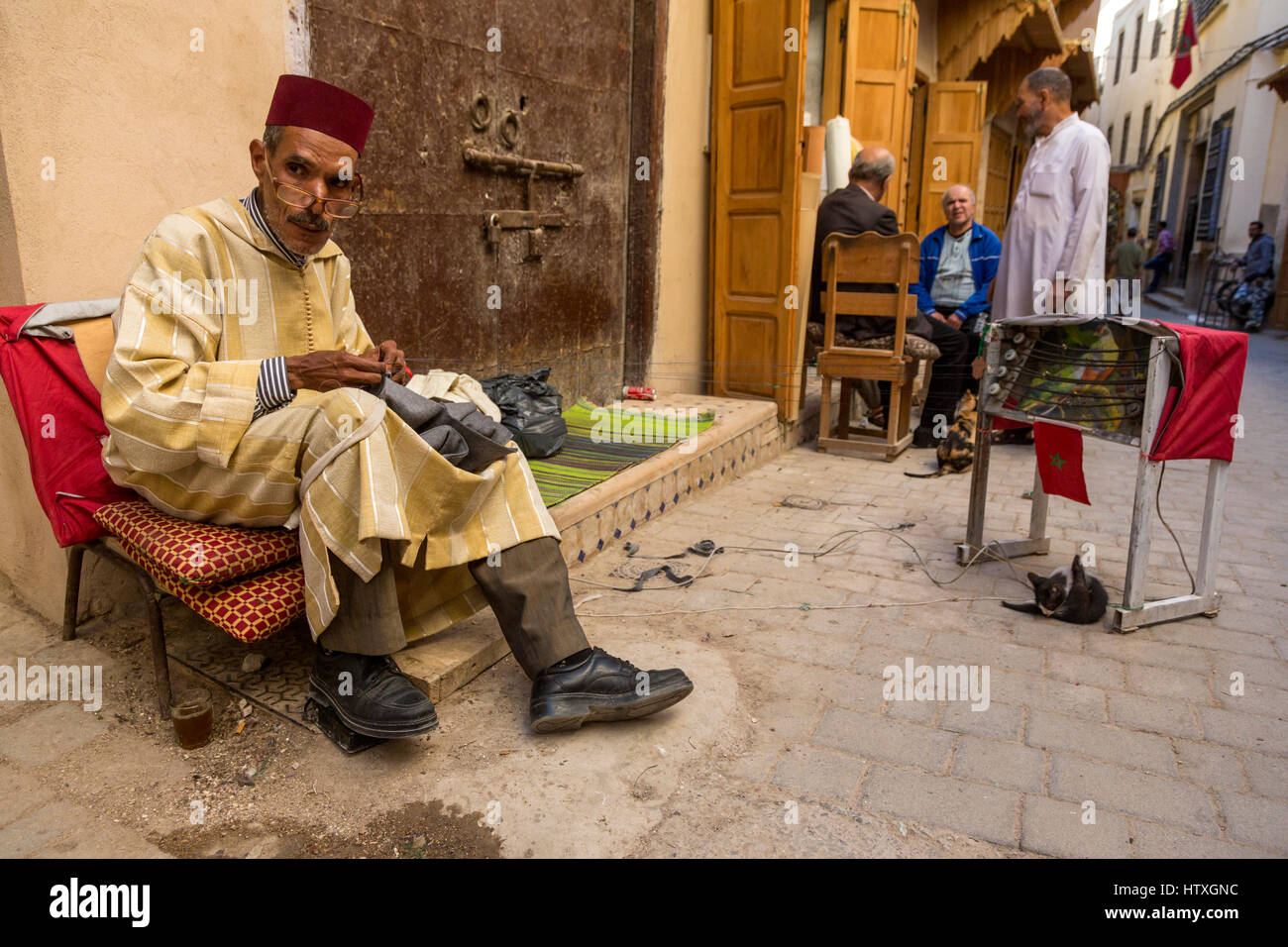 Fes, Marocco. Cucitura su misura un indumento, indossando un Fez e un Djellaba. Foto Stock