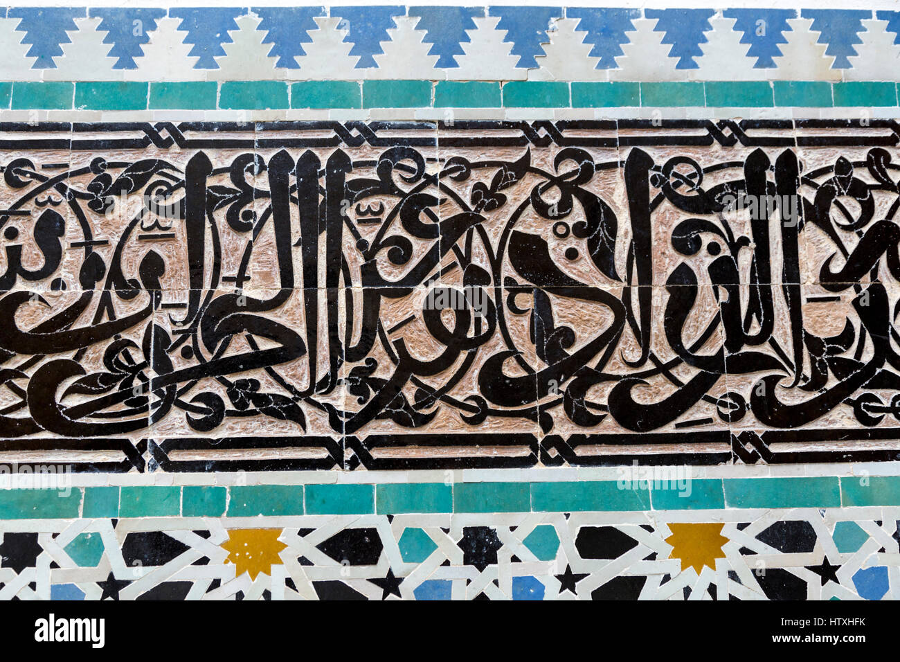 Fes, Marocco. Medersa Attarine, 14th. Secolo. La calligrafia Araba in piastrelle, geometrica delle piastrelle al di sotto. Foto Stock