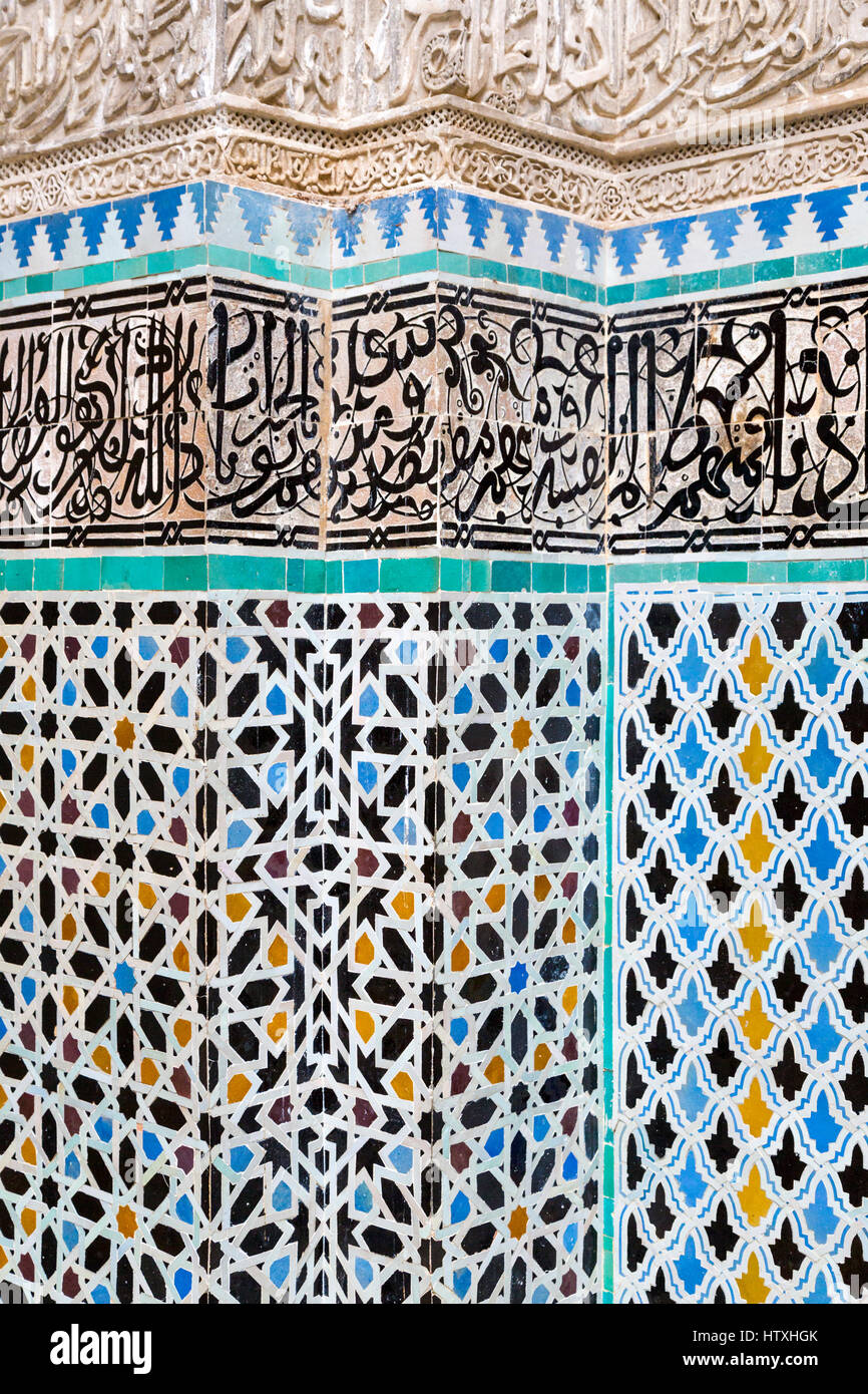 Fes, Marocco. Medersa Attarine, 14th. Secolo. Piastrelle decorative di lavorare sotto la calligrafia Araba su piastrelle, sotto la calligrafia su stucco. Foto Stock