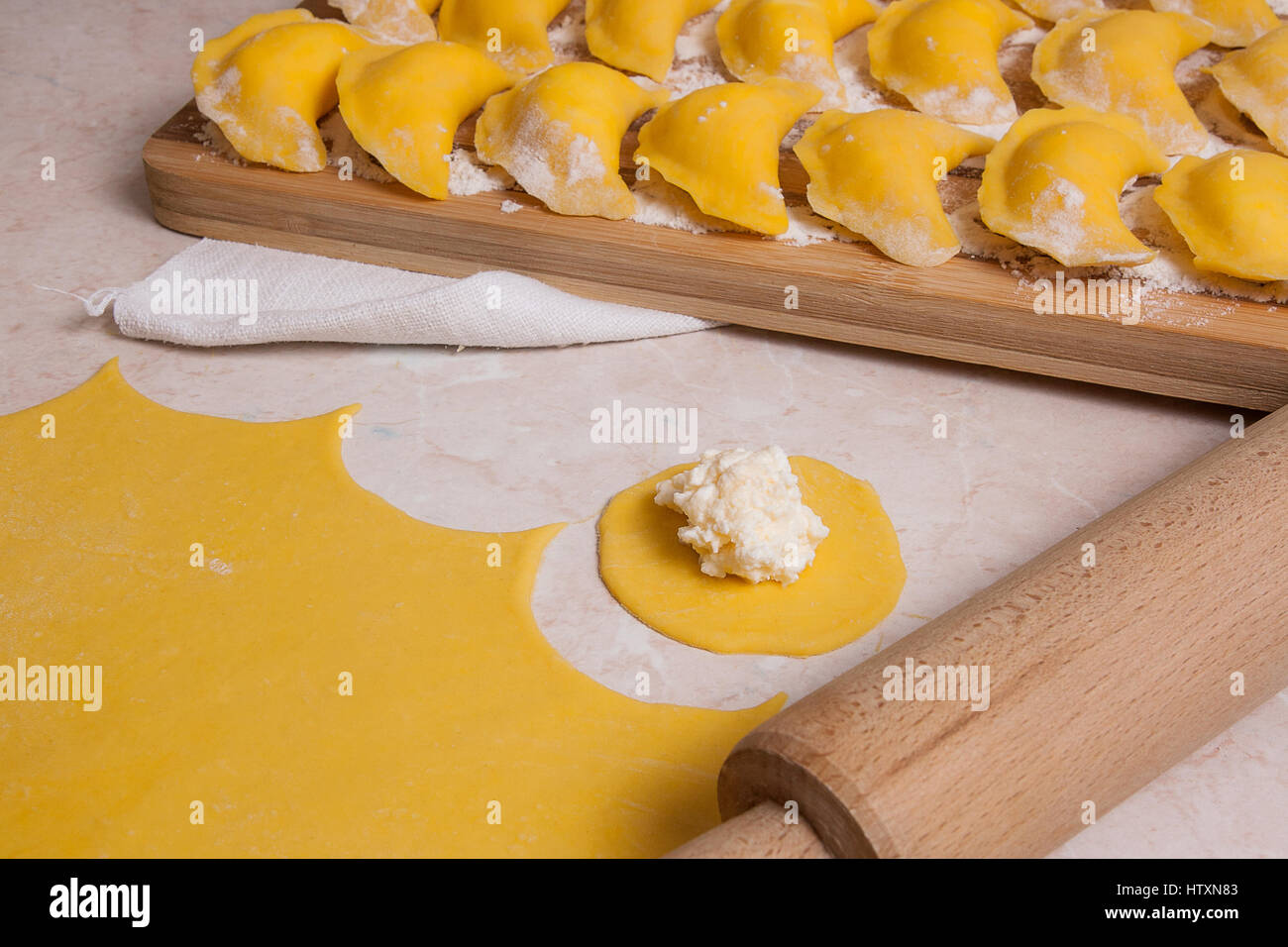 Vista ravvicinata del tondo di pasta e formaggio o ricotta su di esso pronto per preparare varenik o gnocco o pierogi. Pronto per la bollitura vareniki, Foto Stock