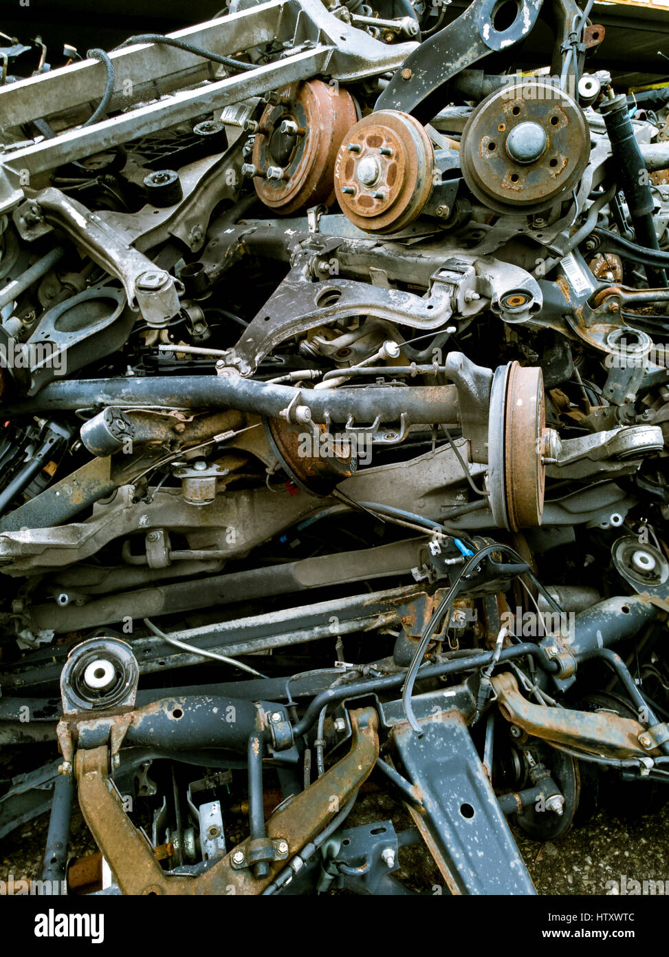 Pila di vecchia auto ammortizzatori e mozzo del freno per il riciclaggio Foto Stock