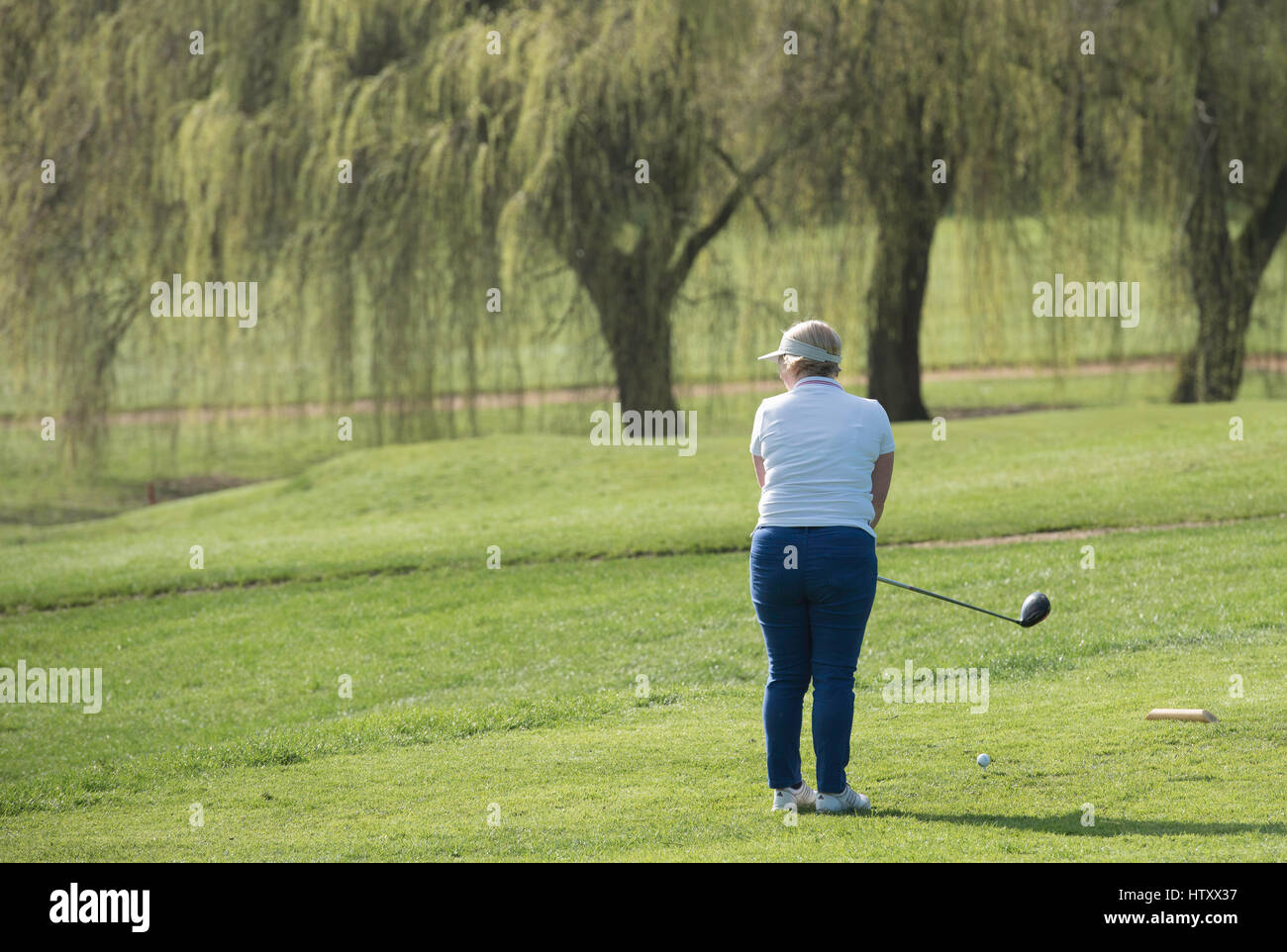 Senior lady golfista prende uno swing Foto Stock