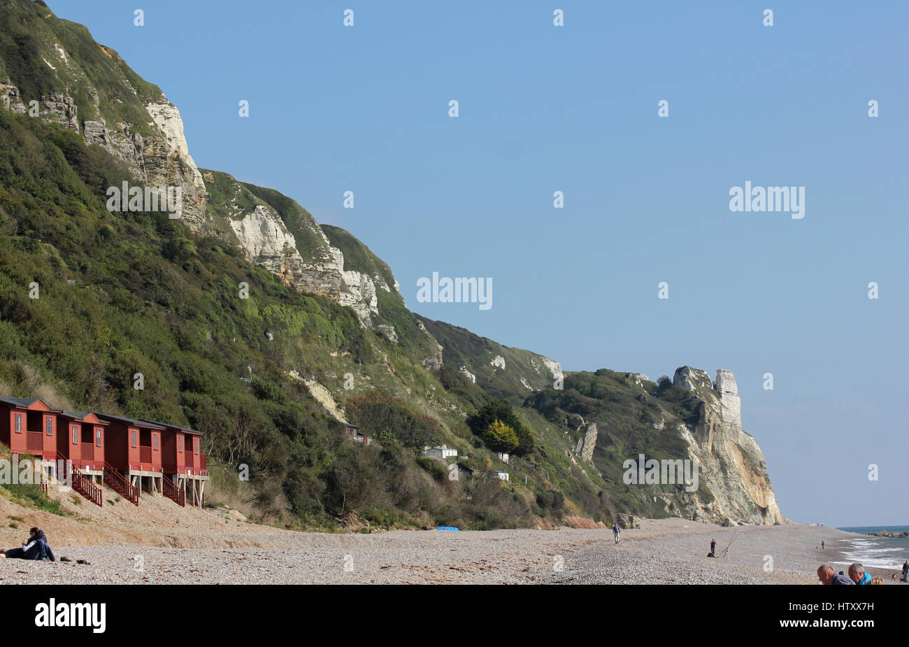 Cabine mare e le scogliere tra Branscombe e testa di birra, Devon, guardando ad est da Branscombe beach in una giornata di sole con cielo blu Foto Stock