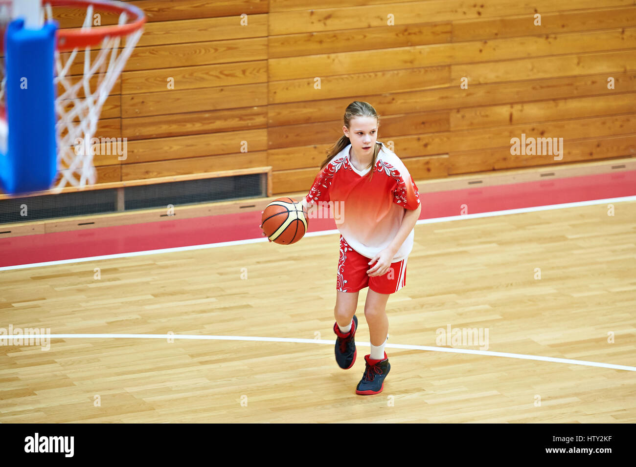 Ragazza atleta nello sport uniforme di giocare a basket Foto Stock