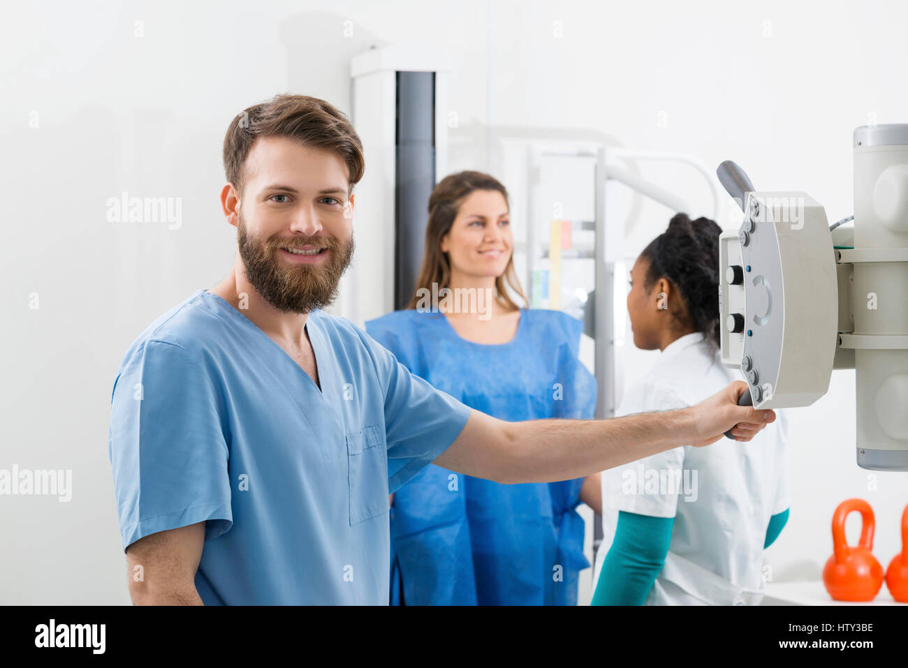 I radiologi preparando per raggi x su femmina paziente in ospedale Foto Stock