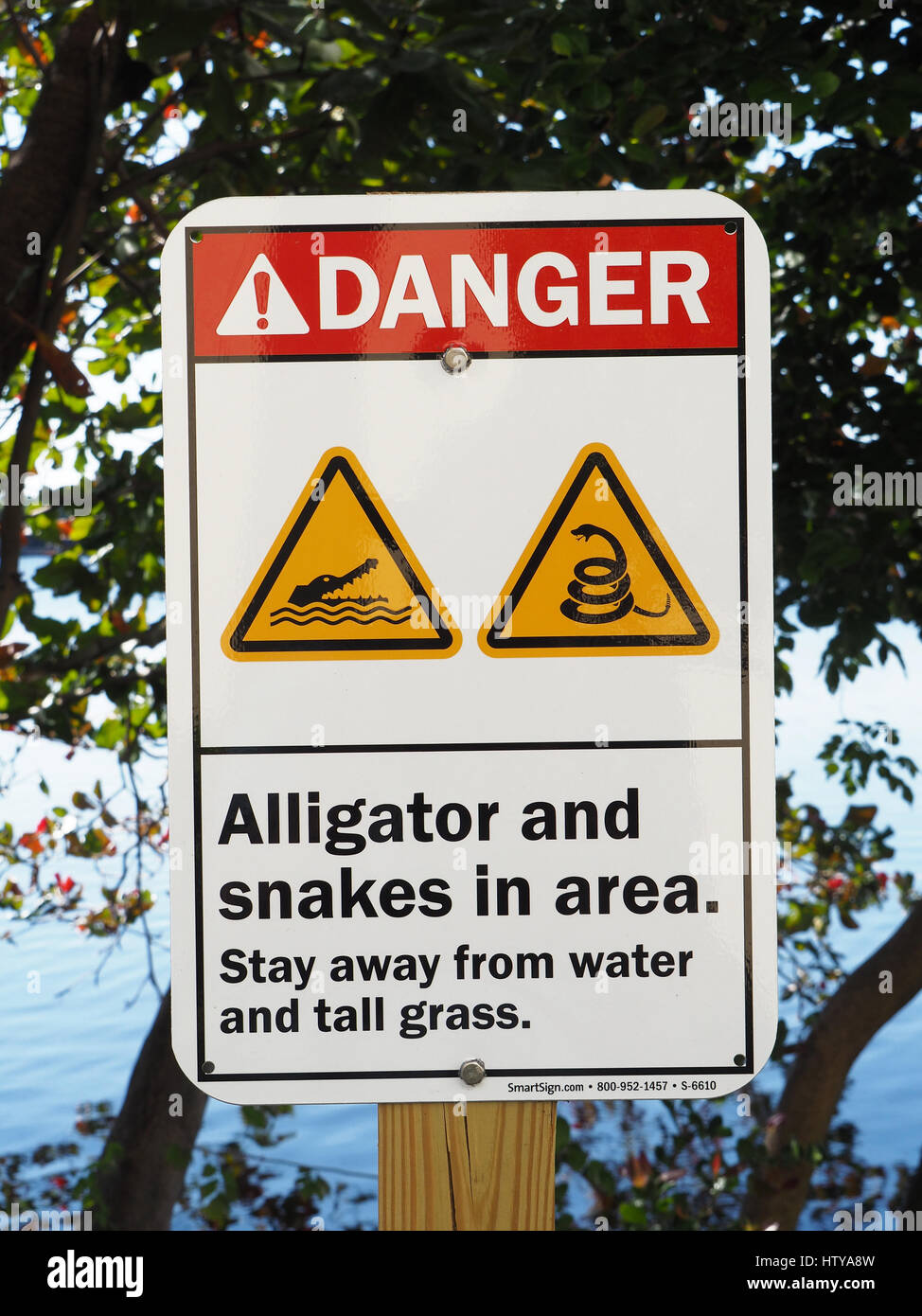 Miami, Florida, segno di avvertimento del pericolo di alligatori e serpenti accanto alla laguna. Foto Stock