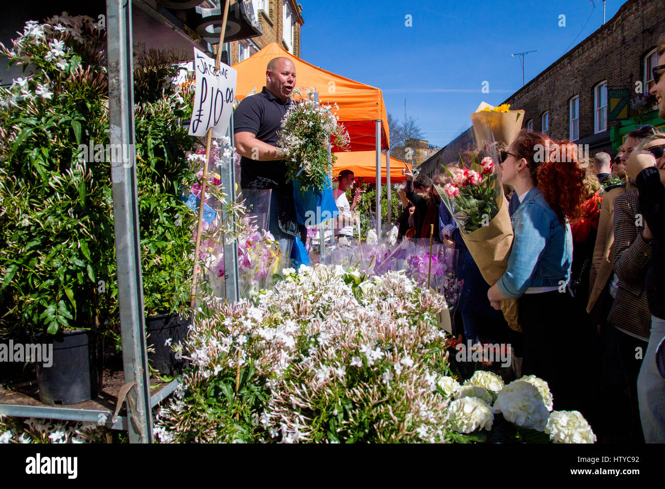 London, Regno Unito - 17 Aprile 2015: Columbia Road Flower mercato domenicale. Commercianti di strada stanno vendendo i loro stock, persone che scelgono i fiori Foto Stock
