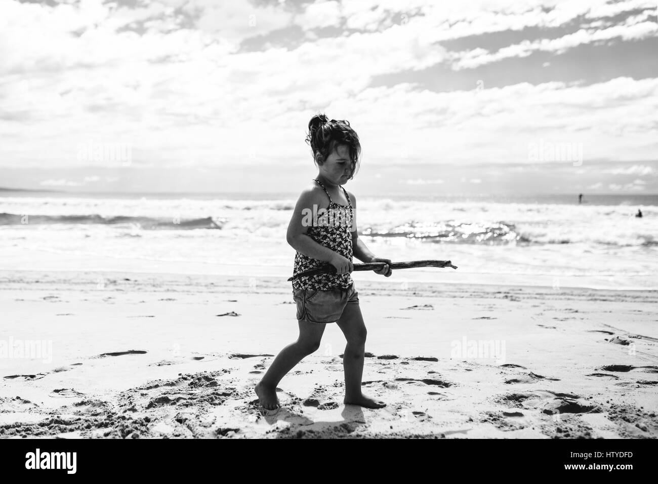 Ragazza camminare sulla spiaggia tenendo un bastone, teste di Noosa, Queensland, Australia Foto Stock Ragazza camminare sulla spiaggia tenendo un bastone, teste di Noosa, Queensland, Australia Foto Stock