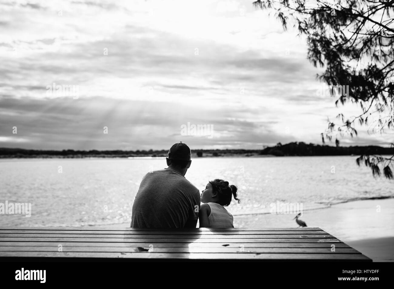 Padre e figlia seduti in riva al mare, teste di Noosa, Queensland, Australia Foto Stock Padre e figlia seduti in riva al mare, teste di Noosa, Queensland, Australia Foto Stock
