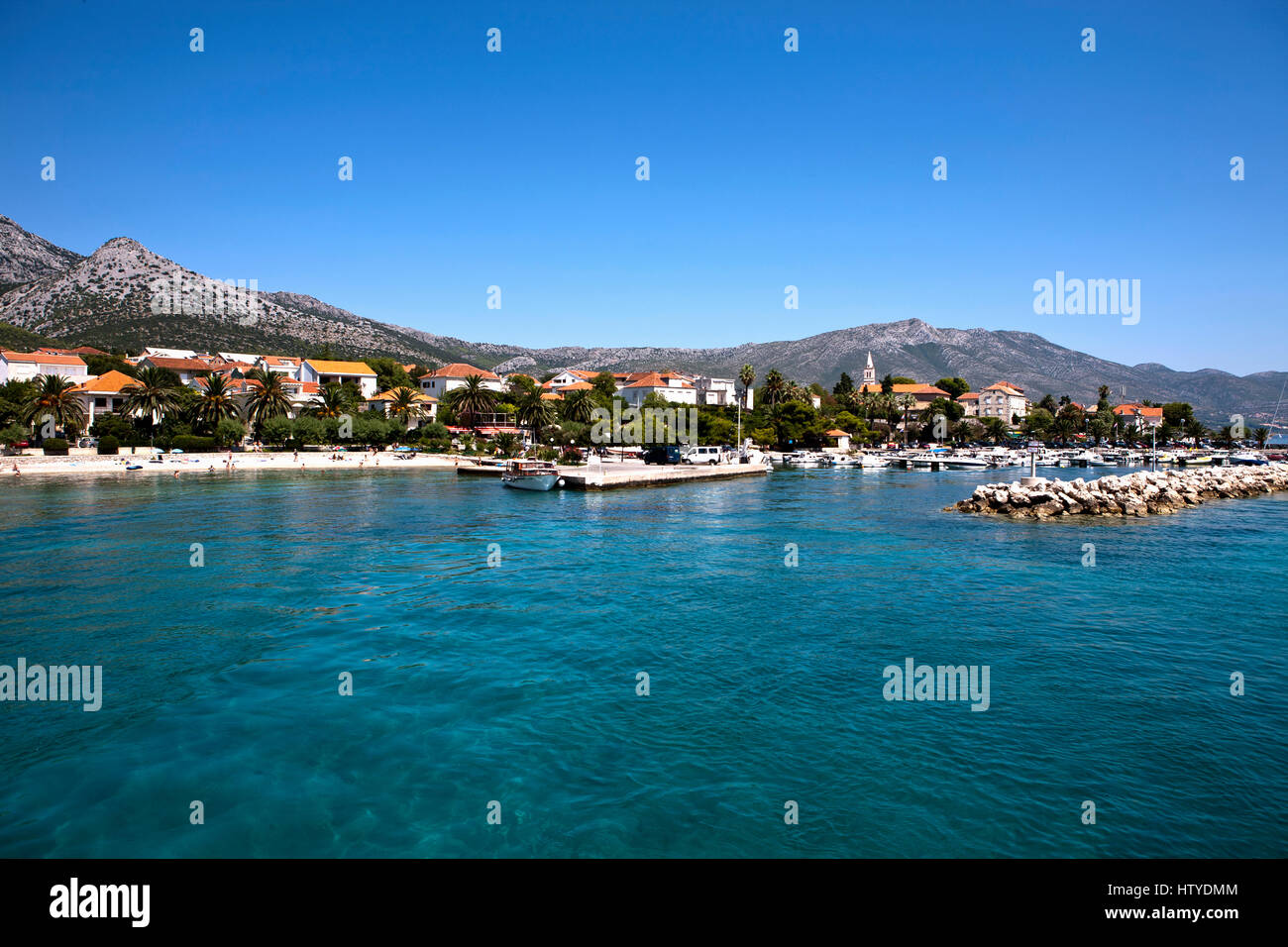 Un piccolo porto con barche si trova accanto ad una piccola spiaggia a Dubrovnik in Croazia. Foto Stock