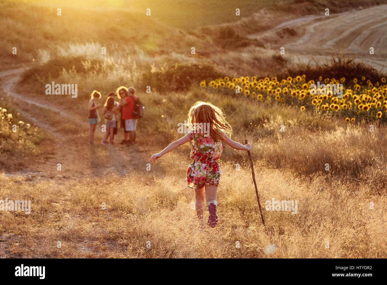 Ragazza che corre verso la famiglia nel paesaggio rurale, Rojas, Spagna Foto Stock