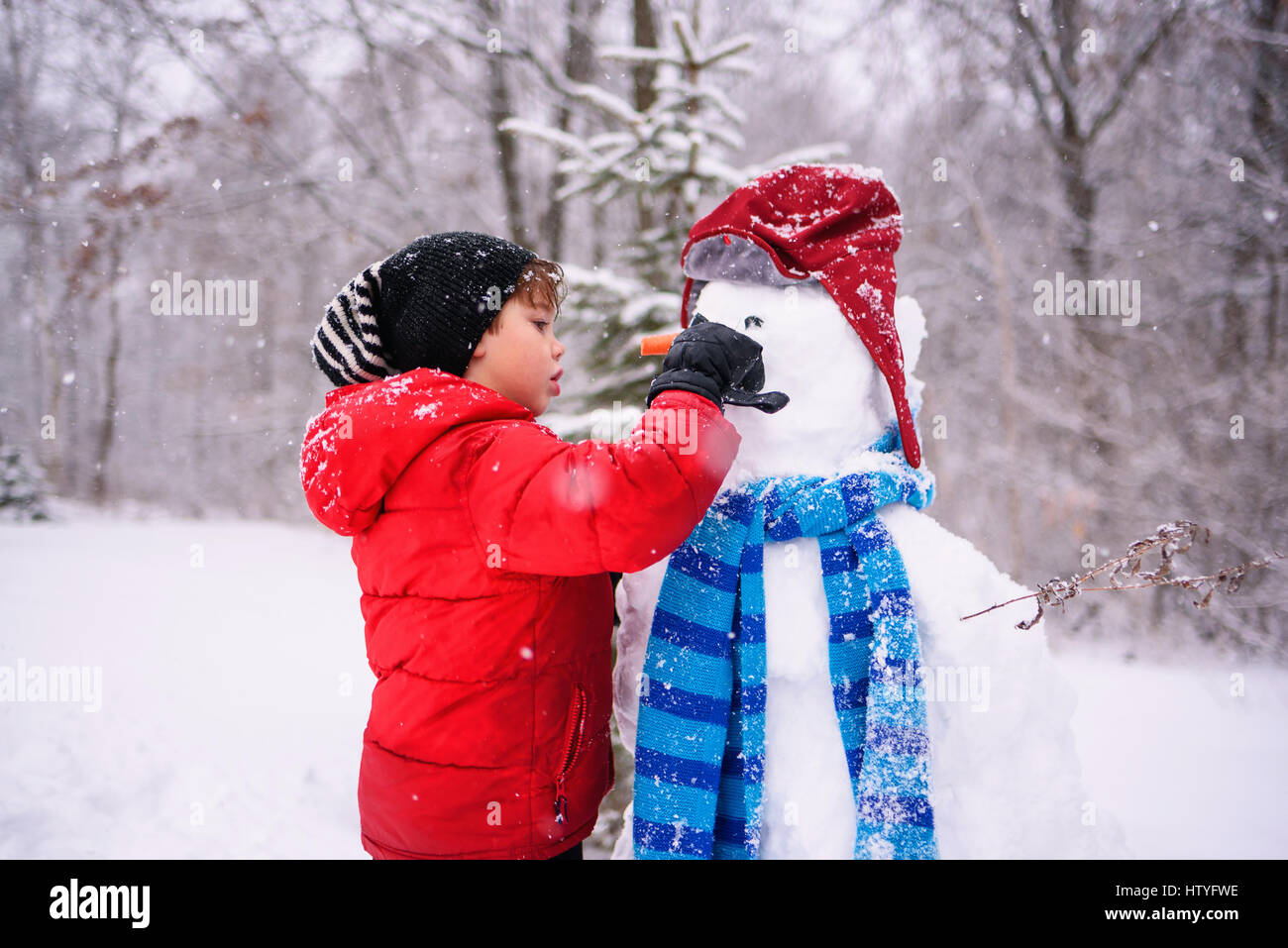 Ragazzo costruire un pupazzo di neve Foto Stock