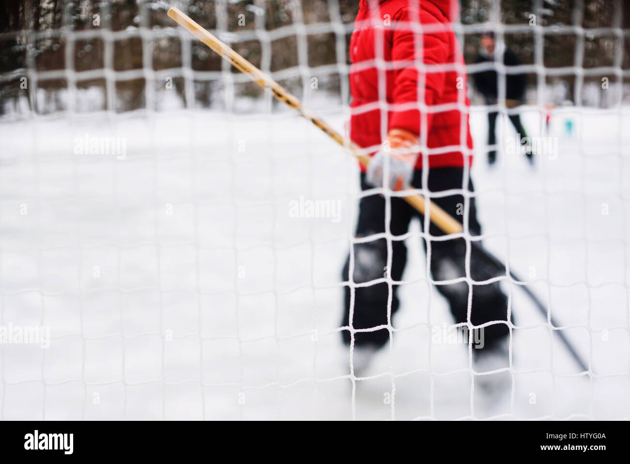 Ragazzo in piedi di hockey su ghiaccio obiettivo Foto Stock