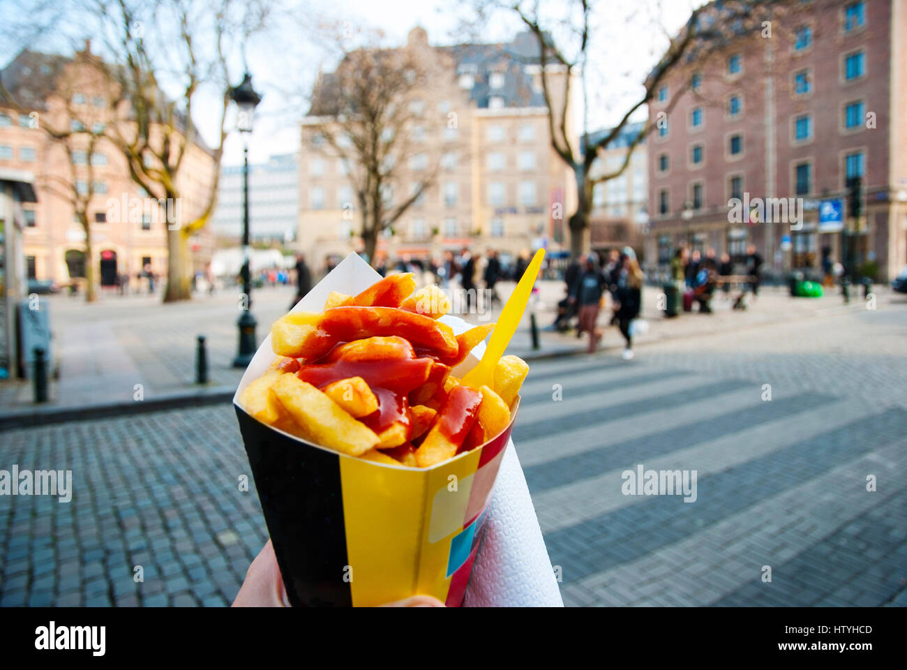 Azienda trypical patatine fritte belghe in mano nelle strade di Bruxelles Foto Stock