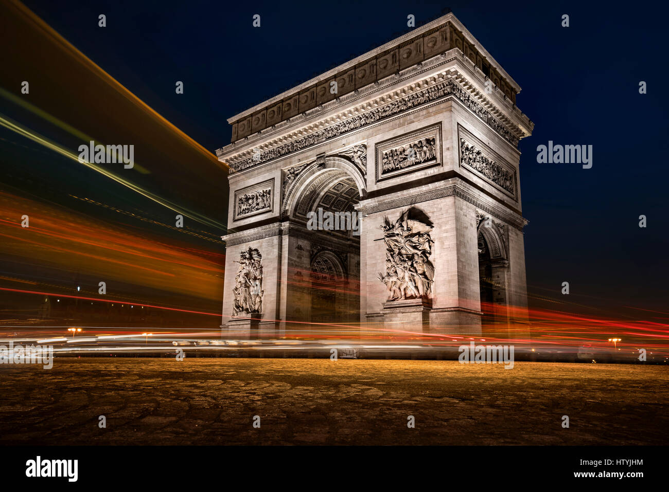 Traffico che passa davanti all'Arco di Trionfo di notte, Parigi, Francia Foto Stock