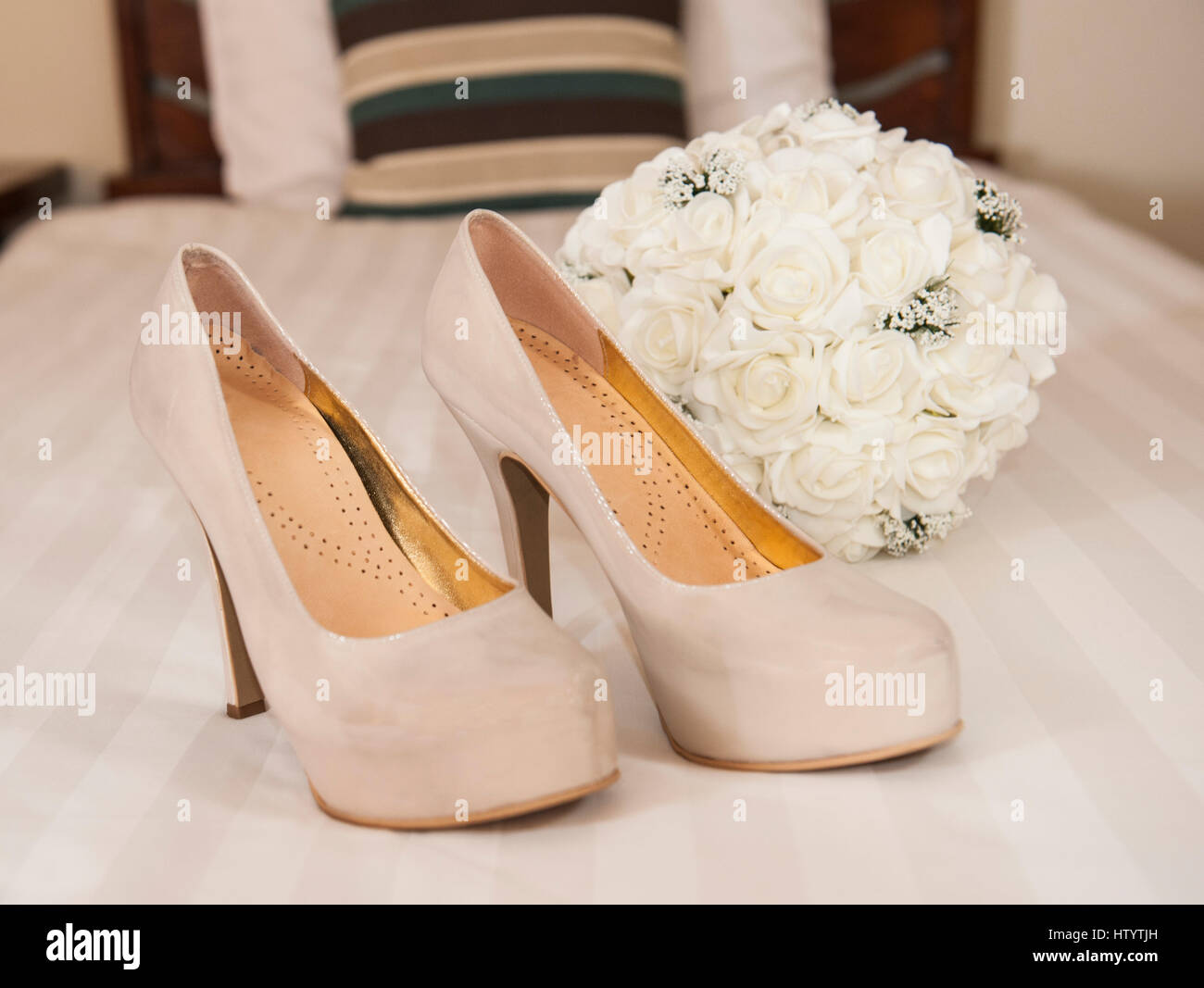 Primo piano dettaglio di alta nuziale piattaforma con tacco stiletto scarpe matrimonio con bouquet di fiori Foto Stock
