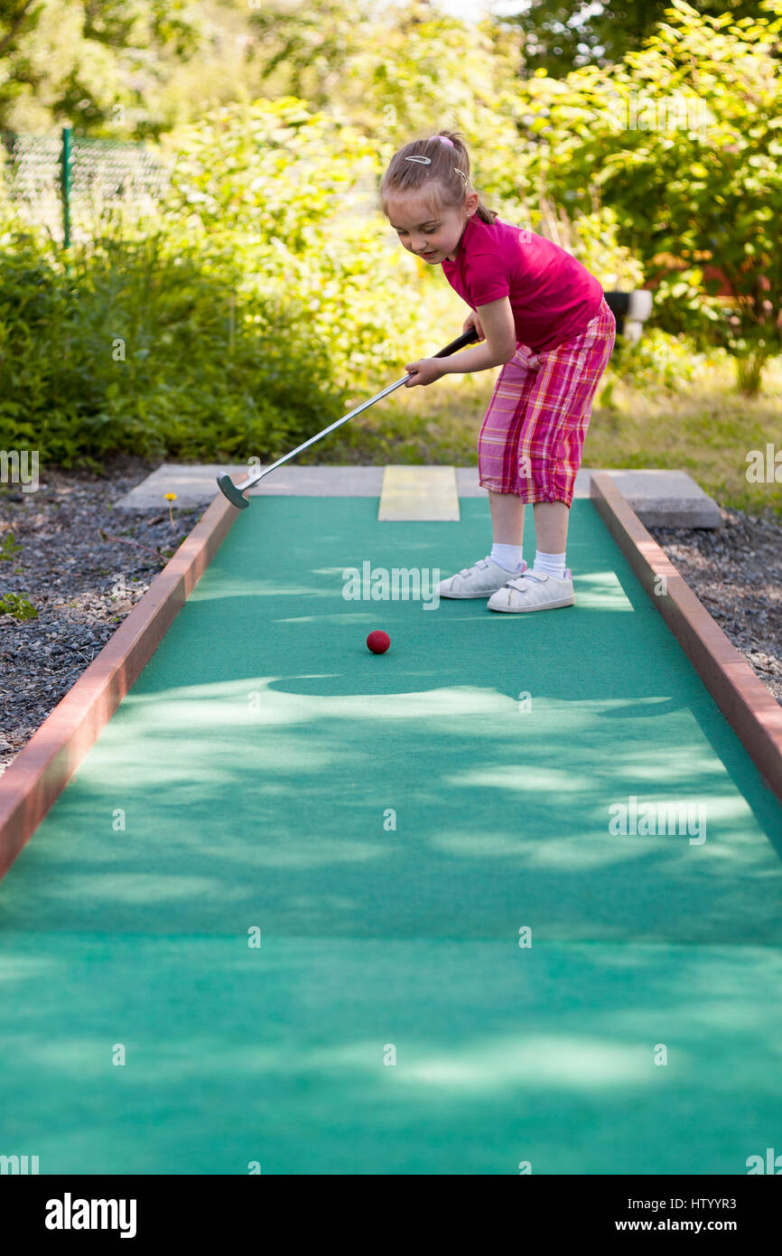 Ragazza giovane giocando crazy mini golf in miniatura all'aperto modello di rilascio: Sì. Proprietà di rilascio: No. Foto Stock