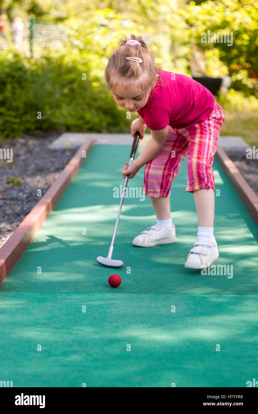 Ragazza giovane giocando crazy mini golf in miniatura all'aperto Foto Stock