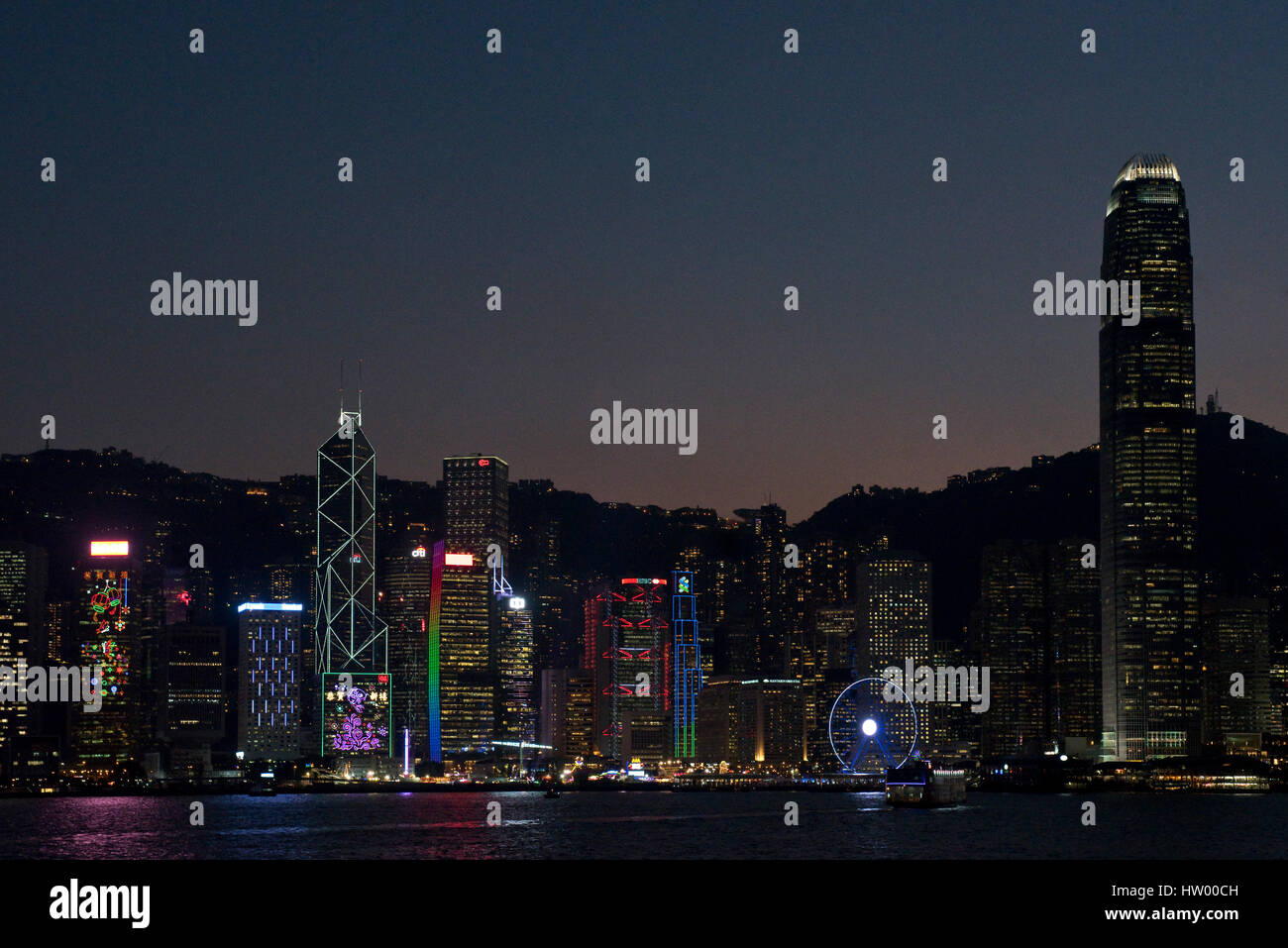 Un variopinto paesaggio visuale degli edifici lungo l'Isola di Hong Kong da Kowloon Public Pier di notte. Foto Stock