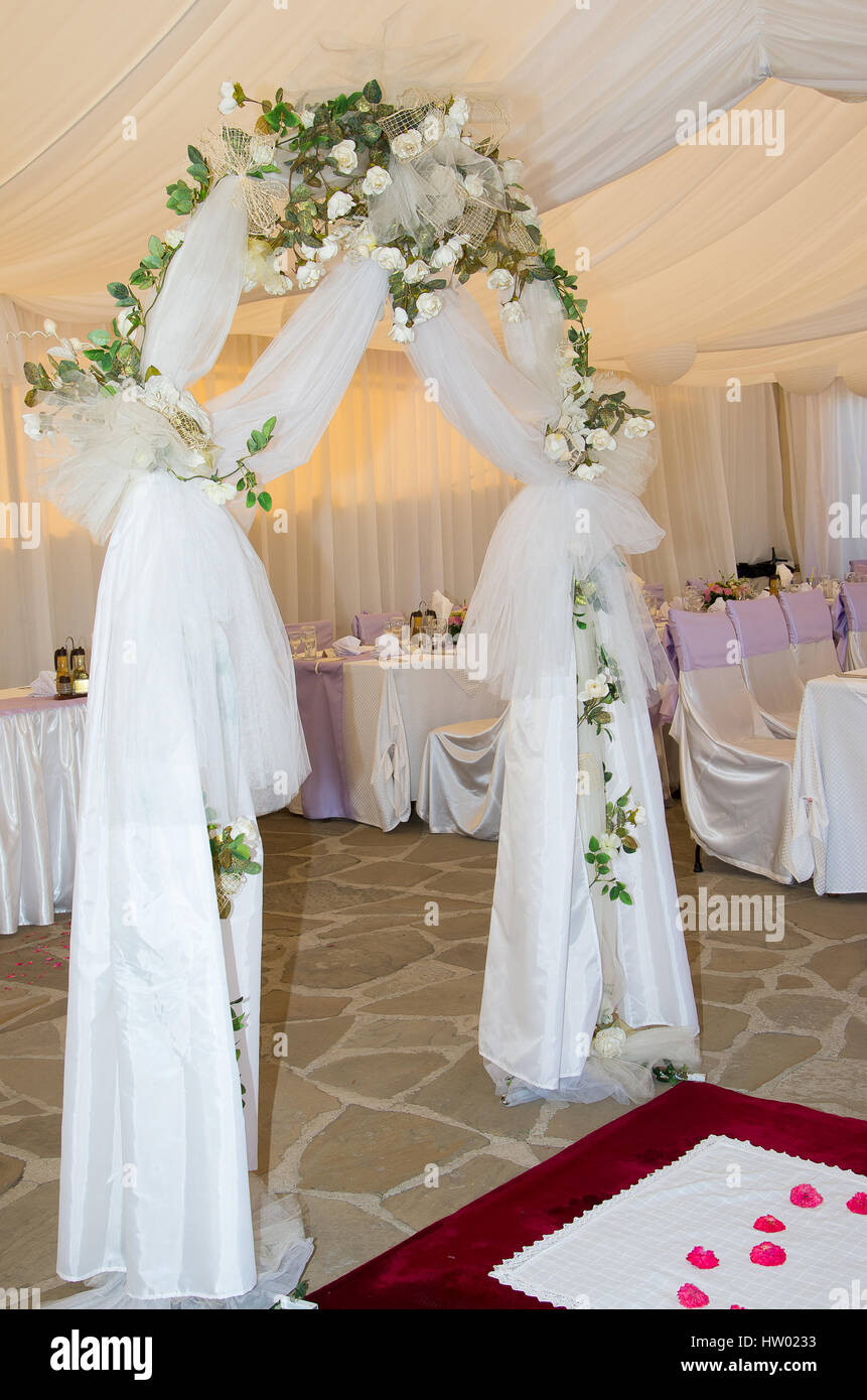 Arco di nozze decorata con velo e rose bianche. Foto Stock