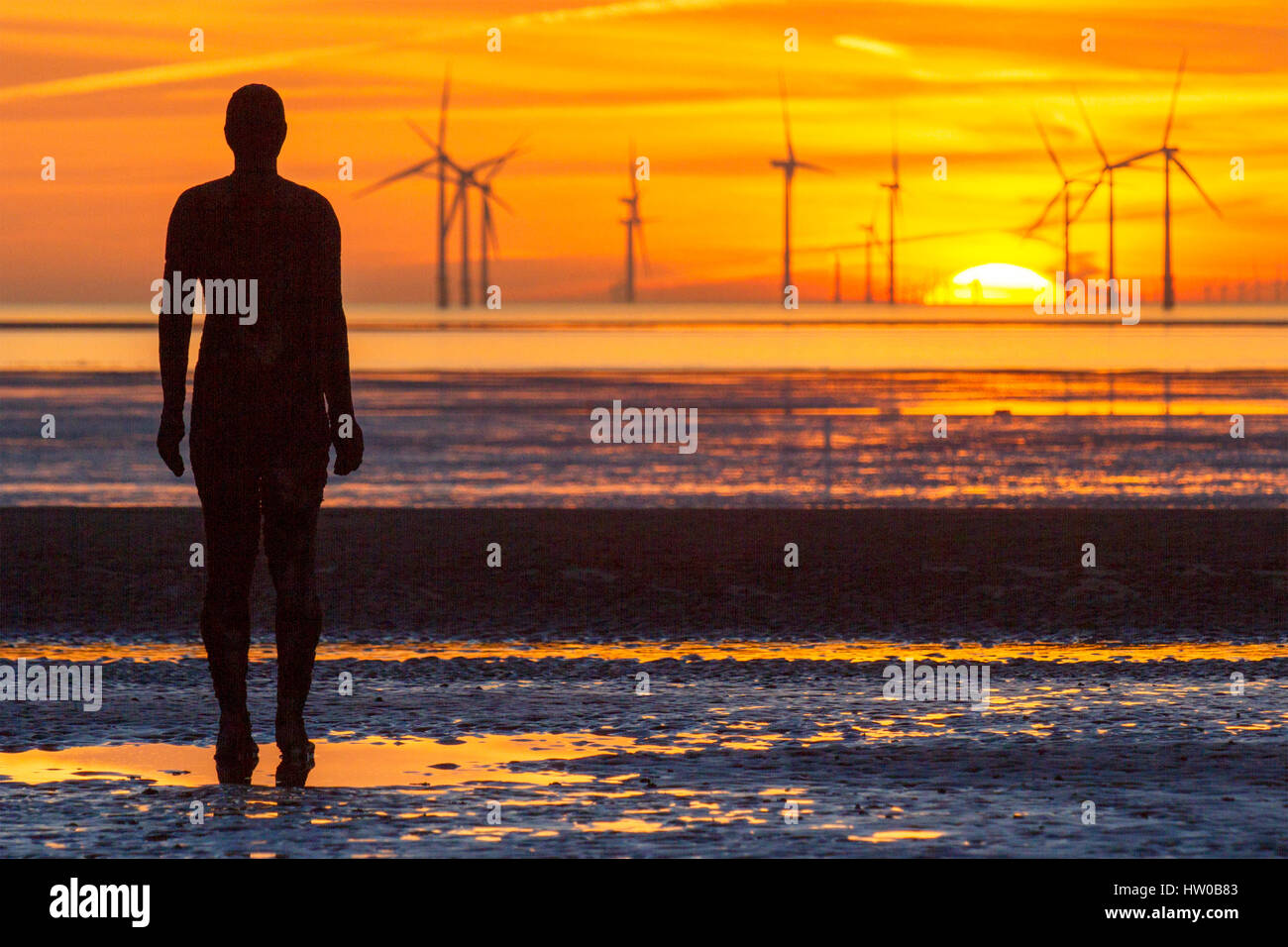 Sunset over Crosby, Liverpool. Il 15 marzo 2017. Dopo una bella e calda e soleggiata giornata di primavera, il sole tramonta oltre la banca Burbo fattoria eolica off il Liverpool Costa. La Banca Burbo Offshore Wind Farm è un 90 MW offshore wind farm situato sulla Burbo Appartamenti in Liverpool Bay sulla costa occidentale del Regno Unito nel Mare d'Irlanda. Un 25 installazione della turbina utilizzando Siemens Wind Power 3.6 MW è stato costruito dal 2005 e ufficialmente inaugurato nel 2007. Credito: Cernan Elias/Alamy Live News Foto Stock