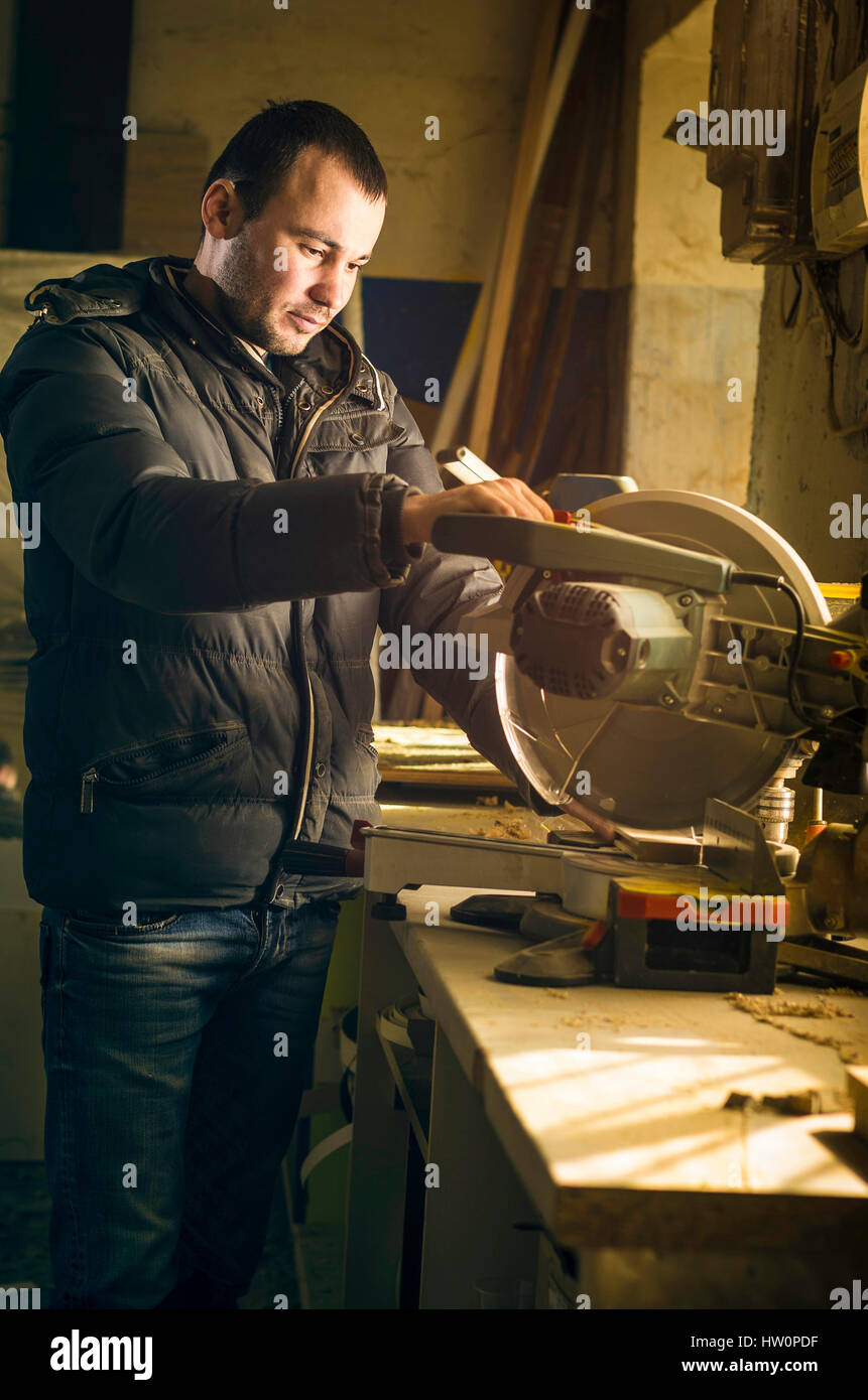 L'uomo facendo qualche lavoro di falegnameria in officina. Foto Stock