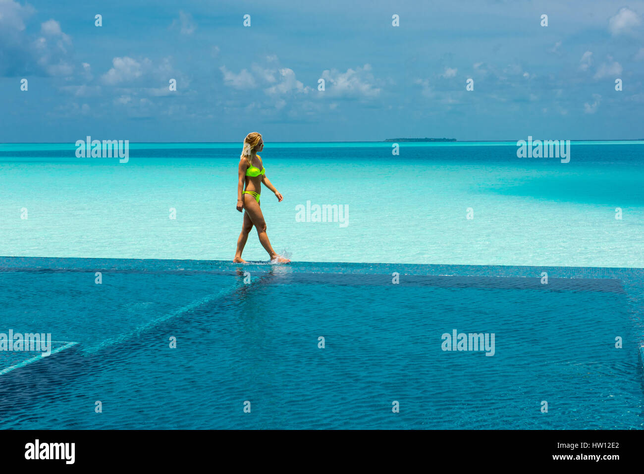 Maldive Rangali Island. Conrad Hilton Resort. La donna nel pool infinty vicino all'oceano. (MR) Foto Stock