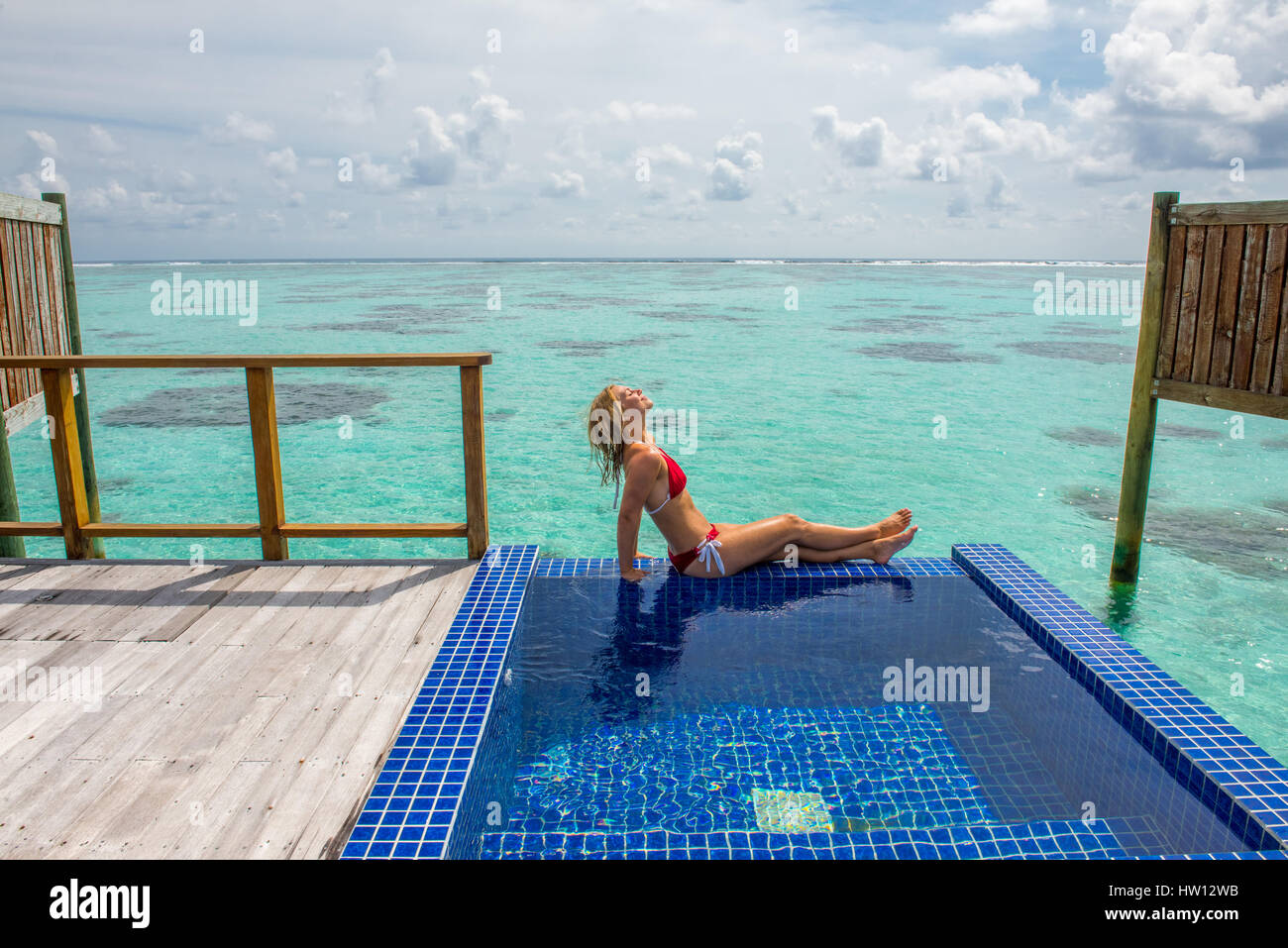 Maldive Rangali Island. Conrad Hilton Resort. Donna rilassante nell'oceano villa piscina che si affaccia sull'oceano. (MR) Foto Stock