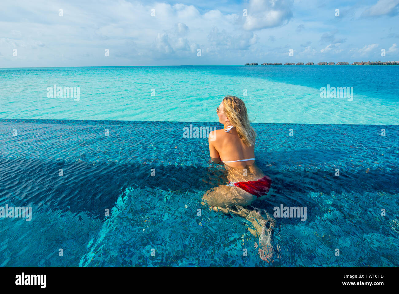 Maldive Rangali Island. Conrad Hilton Resort. La donna in una piscina infinity sull'oceano. (MR) Foto Stock