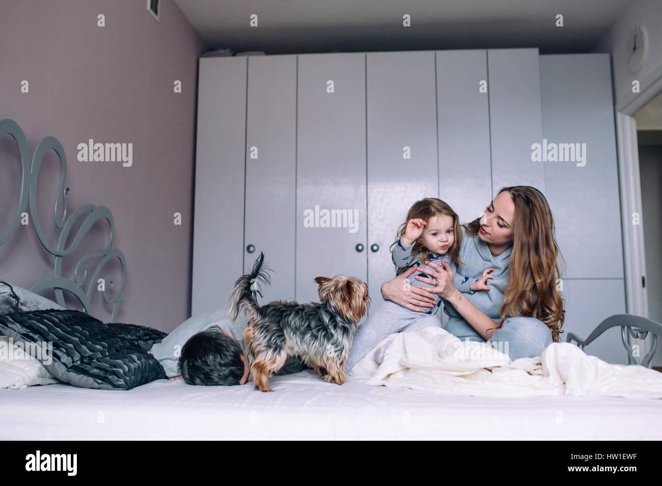 Madre, padre,e il bambino sul letto Foto Stock